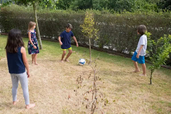 Kids playing soccer in a backyard